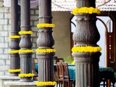 yellow flowers are tied to the pillars outside