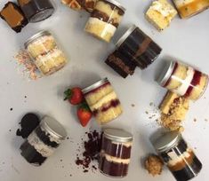 there are many different desserts in jars on the table