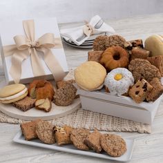 an assortment of cookies and pastries are on the table next to a gift box