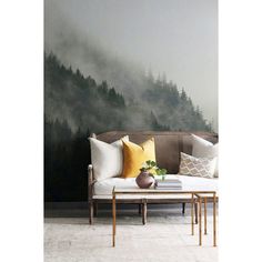 a living room with a couch, coffee table and wall mural