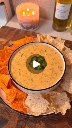 a white bowl filled with dip surrounded by tortilla chips