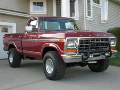 a red pick up truck parked in front of a house