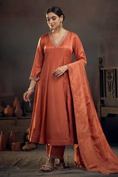 Rust orange kalidar kurta with pita embroidered neckline. Comes with pant and tissue lines dupatta. - Aza Fashions Orange Color Kurti Design, Orange Kurta Woman, Semi-stitched Orange Palazzo Set With Zari Work, Orange Chanderi Set With Gota Work, Orange Palazzo Set With Gota Work For Navratri, Orange Semi-stitched Palazzo Set For Navratri, Orange Palazzo Set With Dupatta And Traditional Drape, Orange Palazzo Set With Resham Embroidery And Traditional Drape, Navratri Orange Palazzo Set With Gota Work