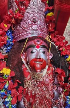 an elaborately decorated statue with flowers around it