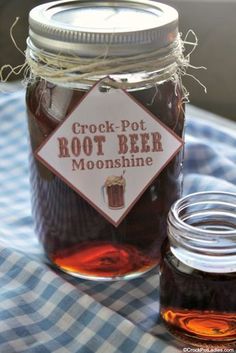 a mason jar filled with root beer sitting on top of a blue and white checkered table cloth