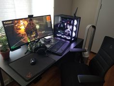 a desk with two monitors and a keyboard