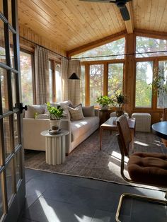 a living room filled with furniture next to a window covered in wood shinnings