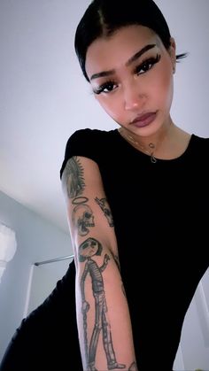 a woman with tattoos on her arm posing for the camera