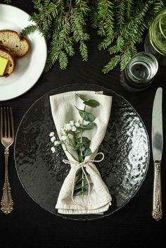 a black plate topped with a piece of bread next to a white plate covered in flowers