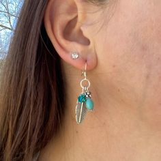 "These silver feather and turquoise dangle earrings feature a Swarovski crystal dangle to add some shine to your ears!  Beautiful silver feathers dangle between a turquoise stone with silver spacers, and a blue zircon Swarovski crystal bicone.  - 2\" total length of earrings - Turquoise stone beads and Blue Zircon Swarovski bicone beads - 3 dangles per earring - lightweight earrings Find more of my earrings here: https://www.etsy.com/shop/fatcatbeads?section_id=42122010 Thank you for shopping wi Adjustable Silver Feather Earrings, Adjustable Silver Earrings With Feathers, Adjustable Dangle Feather Jewelry, Feathered Dangle Jewelry As A Gift, Dangle Feather Jewelry As A Gift, Turquoise Heart Earrings, Sterling Silver Turquoise Earrings, Feather Earrings Silver, Turquoise Dangle Earrings