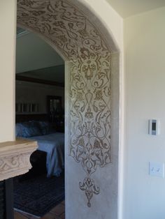 an archway leading into a bedroom with a bed in the background