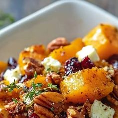 a white bowl filled with fruit and nuts