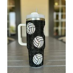 a black and white volleyball tumbler cup on a table