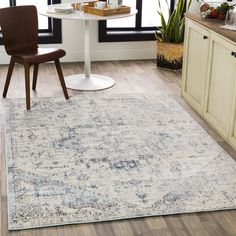 a large rug in the middle of a kitchen with a table and chairs next to it