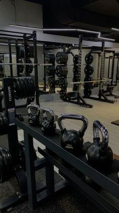 an empty gym with kettles and dumbbells on the rack in front of it