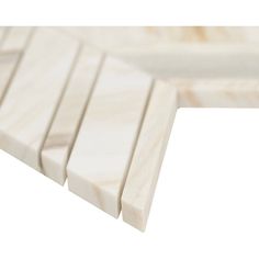 the corner of a white marble shelf with four sections on each side and one section at the end