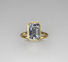 an emerald cut diamond in a yellow gold ring