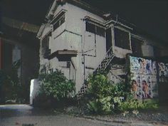 an old building with graffiti on the side and plants growing out of it's balconies