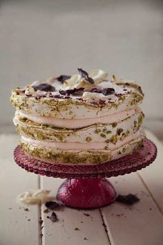 a cake with white frosting and green sprinkles sitting on top of a red plate