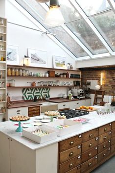 a kitchen filled with lots of counter space next to a skylight over the stove top