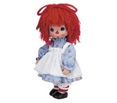 a doll with red hair wearing a blue dress and white apron on it's head