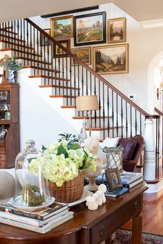 a living room filled with furniture and pictures on the wall next to a stair case