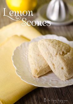 two lemon scones on a white plate next to a yellow napkin