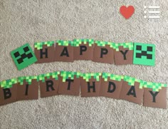 two pieces of paper cut into the shape of a happy birthday banner on carpeted floor