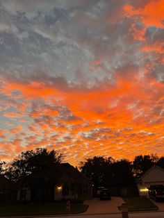 an orange and pink sky at dusk with clouds