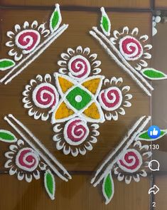 an intricate design on the floor in front of a wooden door with flowers and leaves painted on it