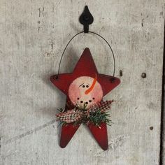 a red star hanging on the wall with a snowman ornament attached to it