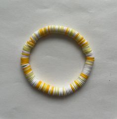 Handmade Yellow and White Clay Bead Bracelet. There are two shades of Yellow mixed with White. Colorful Beads Bracelets For Beach, Yellow Stretch Bracelet With Colorful Beads For Summer, Yellow Beaded Bracelets With Large Beads For Beach, Yellow Beaded Bracelets For The Beach, Orange Large Beads Bracelets For Beach, Yellow Beaded Bracelet For Beach, Black And Yellow Clay Bead Bracelet, Chunky Yellow Beaded Bracelets For Beach, White Colorful Beads Wristband For Beach