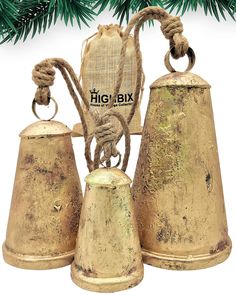 three bells with rope wrapped around them sitting next to a christmas tree ornament