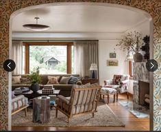 a living room filled with furniture and a fire place in front of a large window