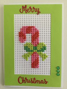 a cross stitch christmas card with the letter c in red, green and white colors