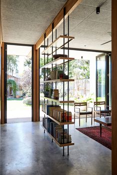 the bookshelf in the living room is full of books and chairs, with sliding glass doors leading outside