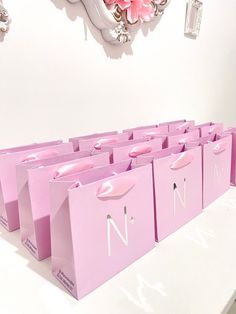 pink shopping bags sitting on top of a white table