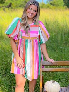 Indulge in the ultimate style statement with our Color Me Pink Striped Babydoll Mini Dress! Embrace the playful and chic vibes of this multicolor striped dress featuring a self-tie at the neck and bubbled sleeves for added flair. Perfect for keeping the colors alive even in the fall, this dress exudes confidence and comfort, making it a must-have piece for your trendy wardrobe. Features: Eye-catching multicolor striped design for a fun and vibrant look. Playful self-tie detail at the neck adds a Trendy Striped Mini Dress For Beach, Trendy Striped Mini Dress For Day Out, Casual Multicolor Striped Dresses, Casual Multicolor Dresses With Vertical Stripes, Casual Multicolor Vertical Stripe Dresses, Casual Multicolor Dress With Vertical Stripes, Spring Multicolor Striped Dresses, Spring Dresses With Vertical Stripes In Multicolor, Trendy Striped Dresses For The Beach