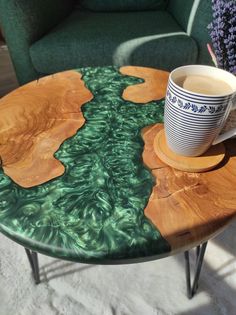 a wooden table with a coffee cup on it and a green couch in the background