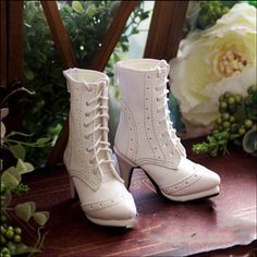 a pair of white boots sitting on top of a table