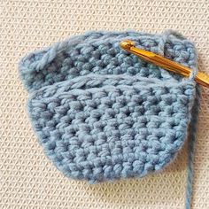 a crocheted blue pouch with a gold metal clip