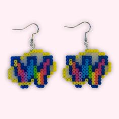 a pair of earrings made out of plastic beads with letters on them and an elephant in the middle