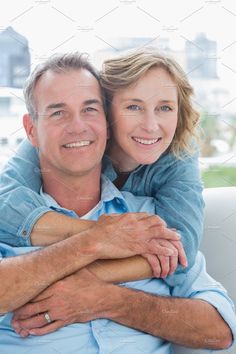 a man and woman hugging each other while sitting on a couch