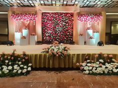 an elaborately decorated stage with flowers and candles on the side for a wedding reception