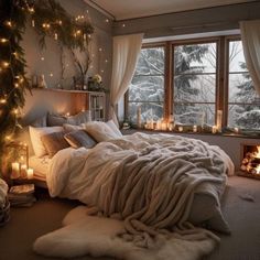 a bedroom decorated for christmas with candles and blankets on the bed in front of a window