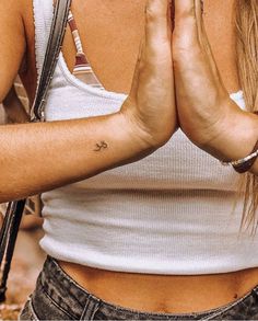 a woman is holding her hands together in front of her face with both hands folded