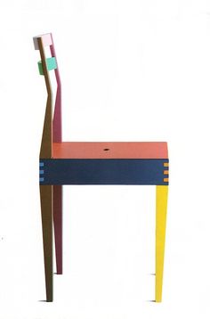 a colorful wooden chair with a long toothbrush sticking out of it's back