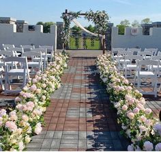 an outdoor ceremony with white chairs and flowers