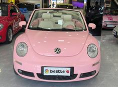 a pink car is parked in a showroom