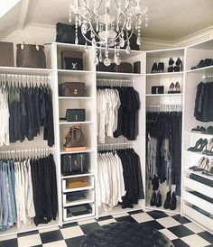 an organized closet with black and white checkered flooring, chandelier and handbags